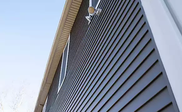Looking up a home exterior with light blue siding