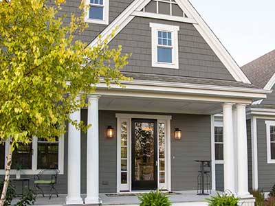 Front of a typical looking home with a porch and gray James Hardie siding