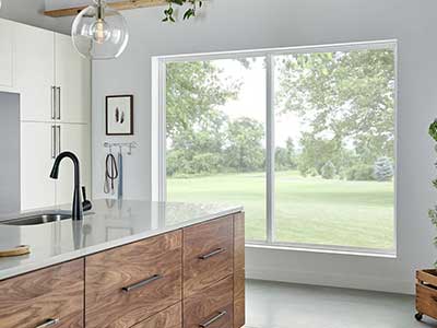 Modern kitchen area with Paradigm windows looking out onto a large open grassy area