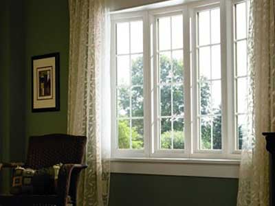 Interior of a home with Simonton windows on a wall with transparent, beige curtains on each side