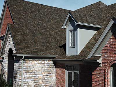 Side view of a typical looking home with brown Owens Corning shingles on its roof
